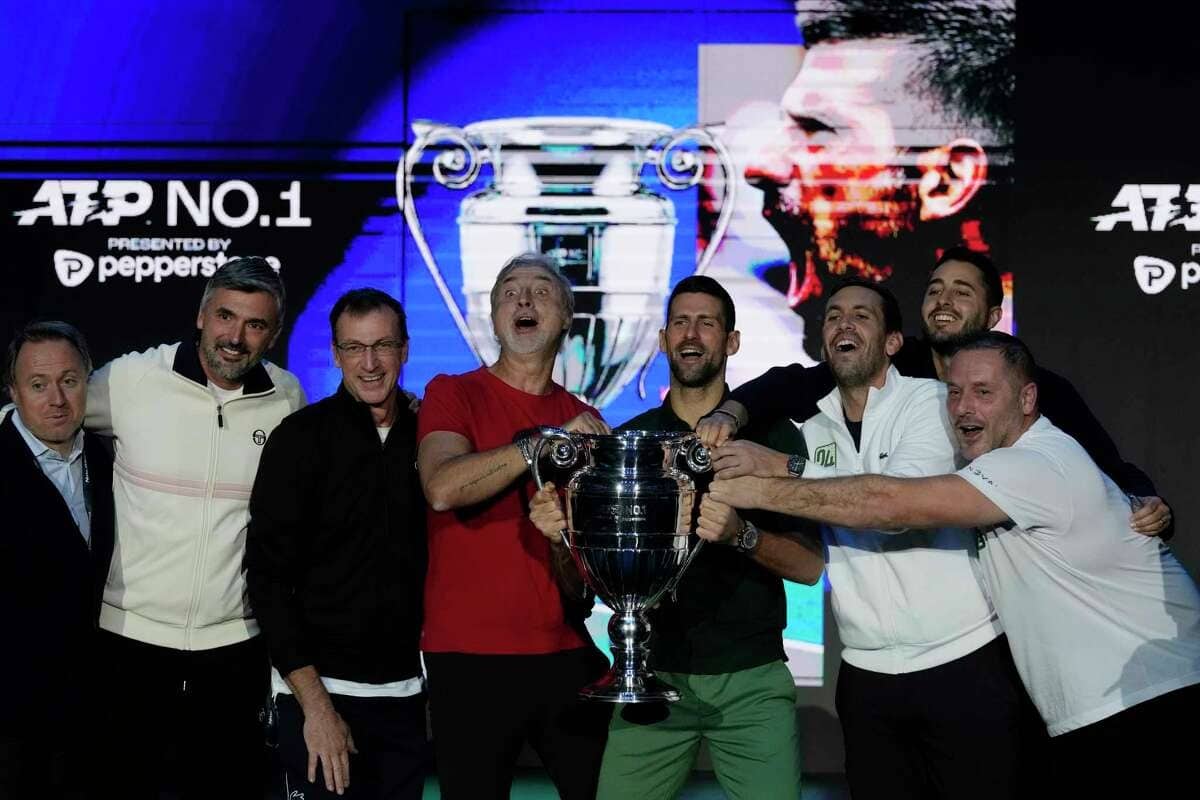 Djokovic (thứ năm từ trái sang) mừng thành tựu cùng đội ngũ, khi nâng cao cup cho tay vợt kết thúc năm ở vị trí số một. Ảnh: AP