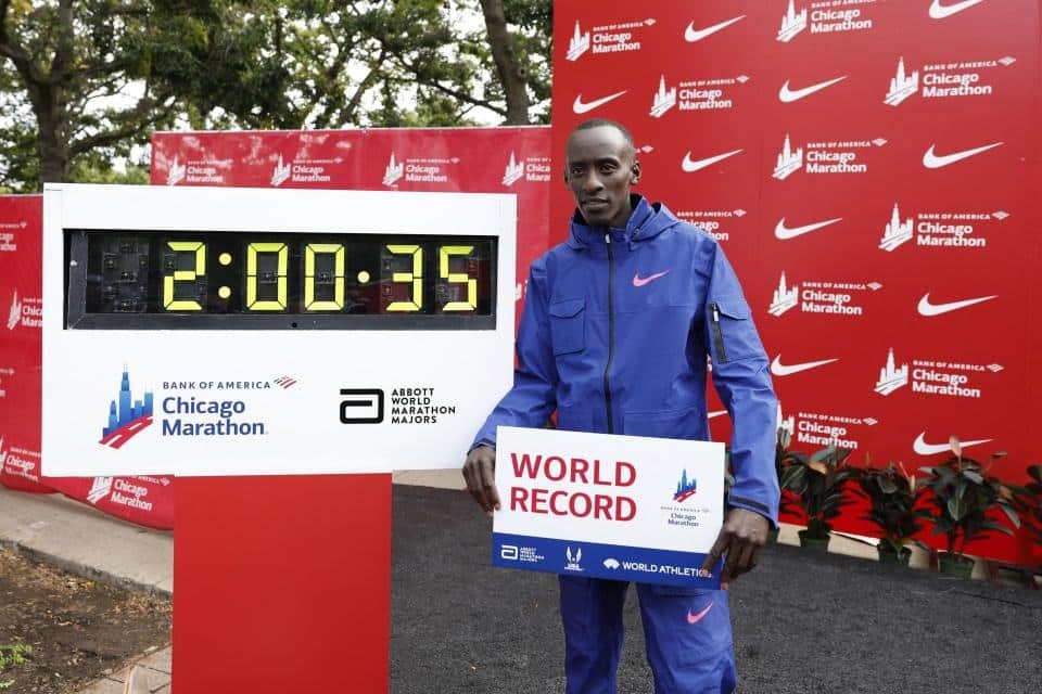 Kiptum khoe bảng kỷ lục thế giới bên cạnh đồng hồ ghi thông số 2 giờ 0 phút 35 giây sau khi về nhất Chicago Marathon 2023 ngày 8/10. Ảnh: AFP